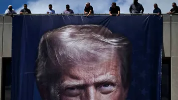 Bannere uriașe cu chipul lui Trump împodobesc unele clădiri federale din Washington D.C. Democrații protestează