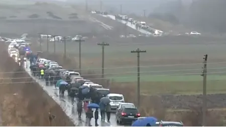 Ploaia nu îi oprește pe credincioși! Mii de oameni parcurg 5 kilometri pe jos până la peștera Sfântul Andrei