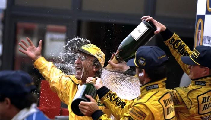 Eddie Jordan (stânga), cu echipa în 1998, celebrând victoria în Marele Premiu al Belgiei F1