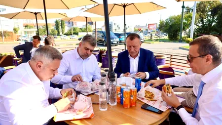 În timp ce firmele românești dau faliment, premierul Ciolacu și alți lideri PSD afișează o imagine în care mănâncă burgeri și beau Pepsi