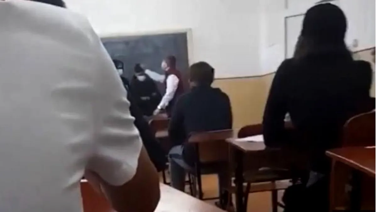 Elev bătut cu palmele peste față de directoare, în faţa clasei